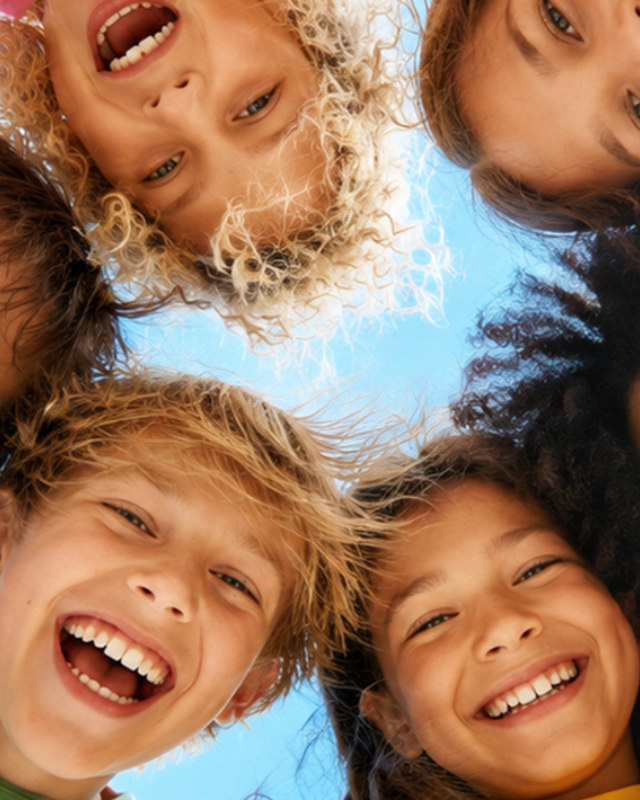 Een groep met blije kinderen die in de camera kijken.